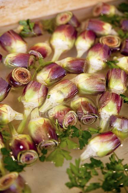 Raw Artichokes and parsley — Stock Photo