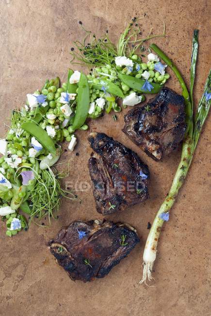 Côtelettes d'agneau grillées avec salade de pois — Photo de stock