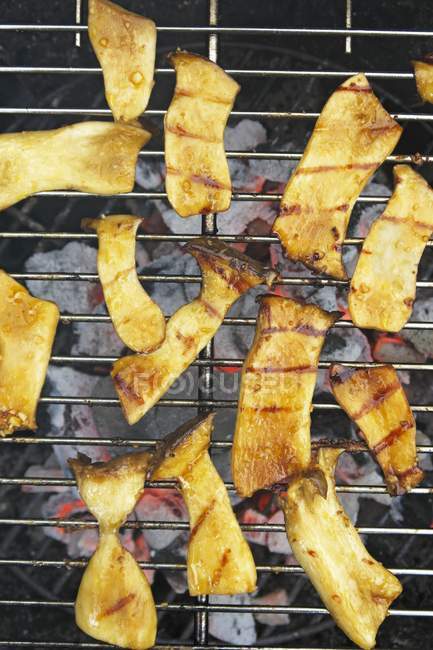King trumpet mushrooms marinated in soy sauce and garlic on a barbecue — Stock Photo
