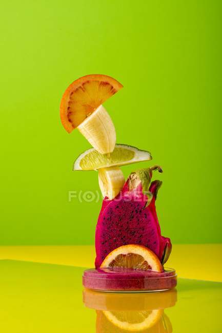 Primo piano vista di scultura fatta di frutta esotica su sfondo colorato — Foto stock