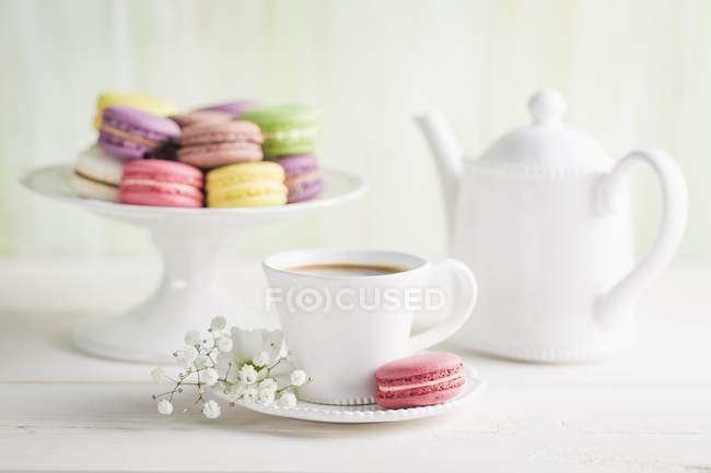 Macarrones coloridos con café - foto de stock