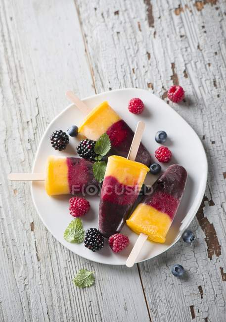 Berry and mango ice lollies — Stock Photo