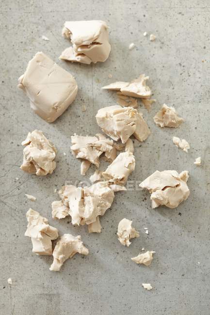 Closeup view of crumbled fresh yeast on a grey surface — Stock Photo