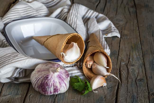 Purple garlic on a tea towel on a rustic wooden table — Stock Photo