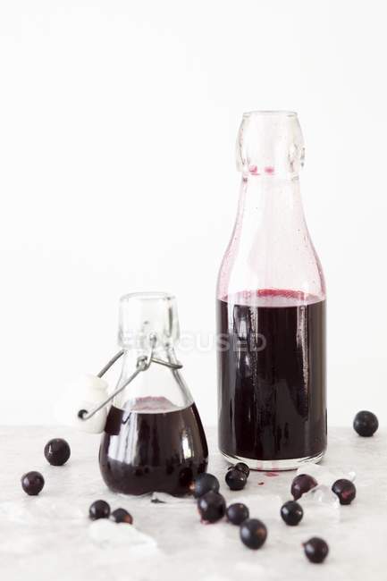 Вид черной смородины и ванильного сиропа в бутылках — стоковое фото