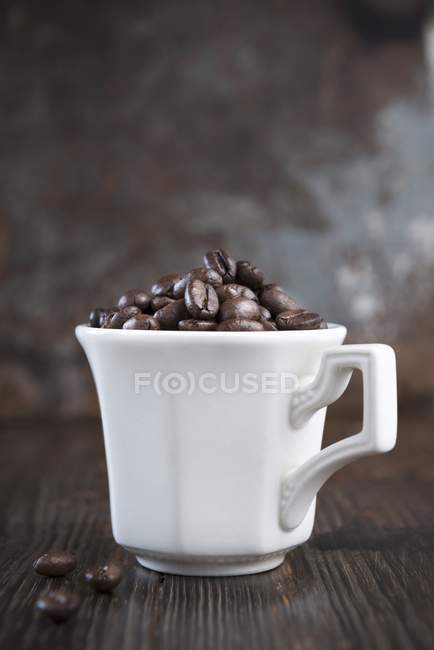 Chicchi di caffè in tazza — Foto stock
