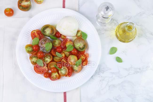 Tomatoes with mozzarella and basil — Stock Photo