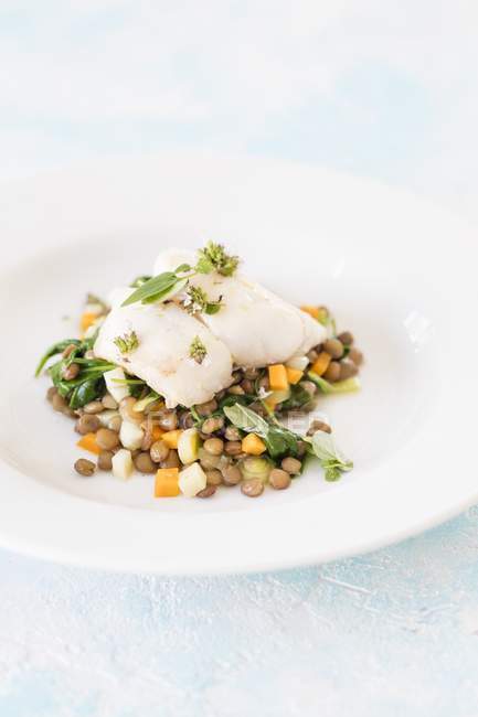 Coalfish with lentils on plate — Stock Photo
