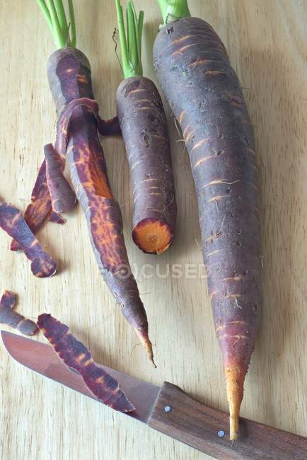 Purple carrots with knife — Stock Photo