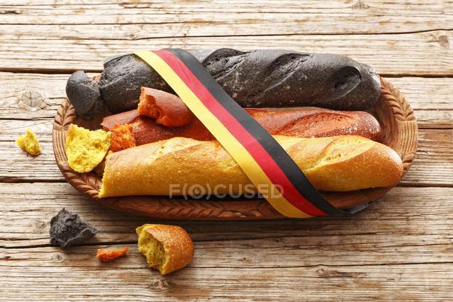 Baguettes schwarz, rot und gold mit Schleife auf Holzoberfläche gebunden — Stockfoto