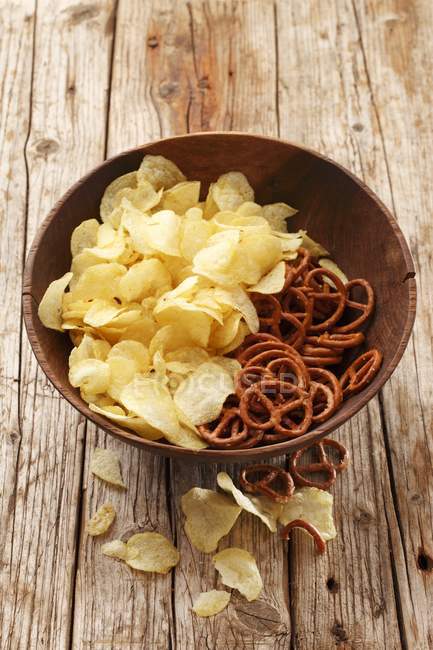Patatas fritas y pretzels en tazón - foto de stock
