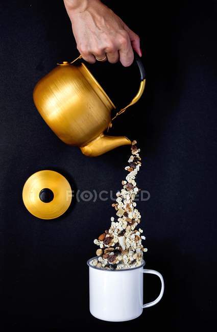 Muesli being poured from teapot — Stock Photo