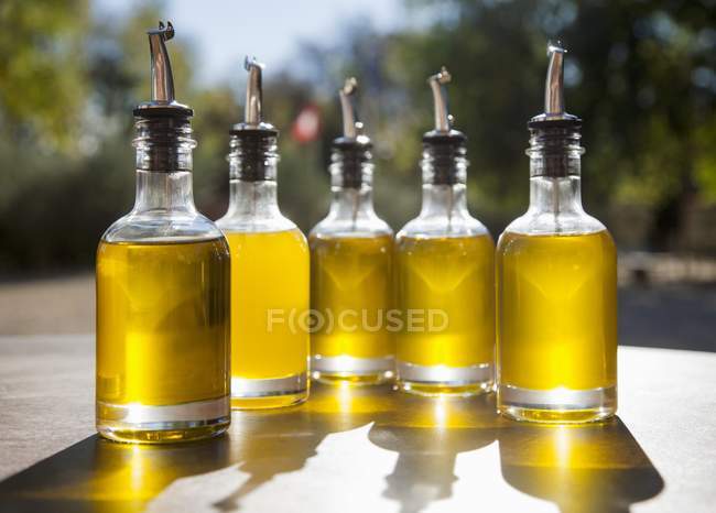 Крупним планом олія в пляшках з наповнювачами на відкритому столі — стокове фото