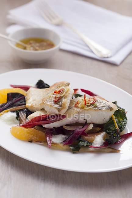 Fillet of fish with chard and orange segments — Stock Photo