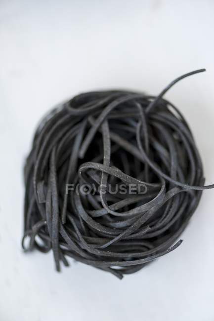 Ninho de massas de macarrão preto sepia linguine — Fotografia de Stock
