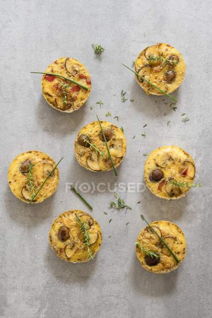 Mini frittatas com cogumelos, pimenta e ervas na superfície cinza — Fotografia de Stock