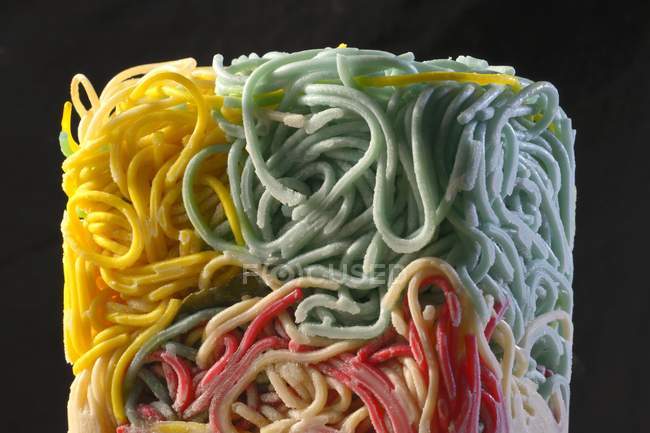Espaguetis coloridos congelados en bloque - foto de stock