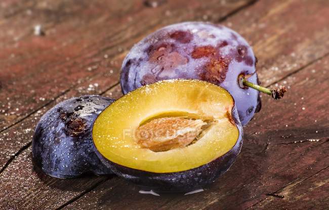Fresh plums with drops of water — Stock Photo