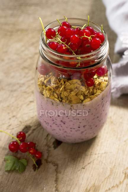 Tarro de desayuno con yogur y grosellas rojas - foto de stock