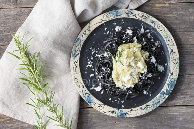 Black linguine pasta with avocado and Parmesan — Stock Photo