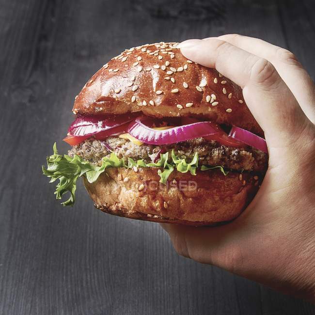 Main tenant un beefburger fait maison — Photo de stock