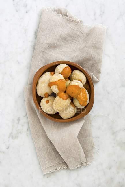 Papas arrugadas potatoes with mojo sauce in bowl over towel — Stock Photo