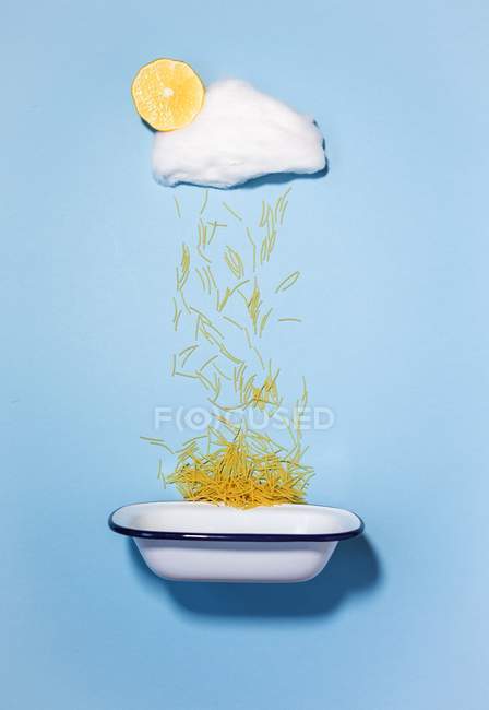 Концепція дощу макаронних виробів, що падає з хмари цукерки в емальовану миску — стокове фото