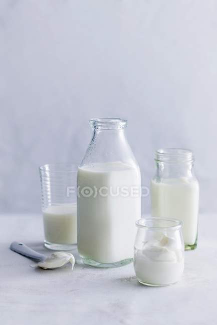 Bodegón con diferentes productos lácteos en recipientes de vidrio - foto de stock