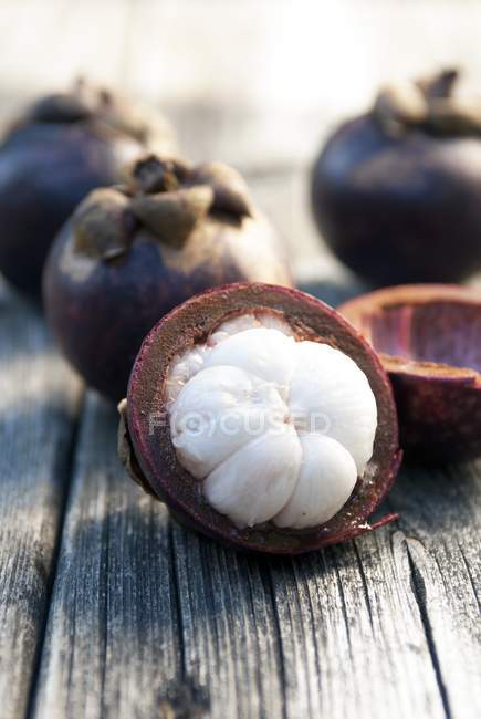 Whole and halved Mangosteens — Stock Photo