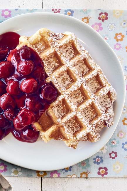 Waffle with cherries on plate — Stock Photo