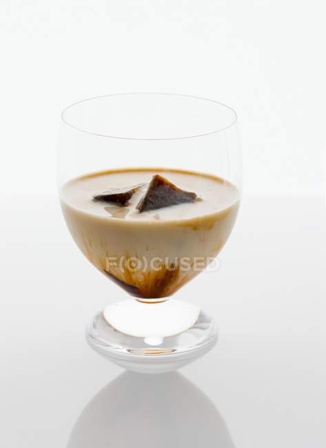 Closeup view of iced coffee glass on white surface — Stock Photo