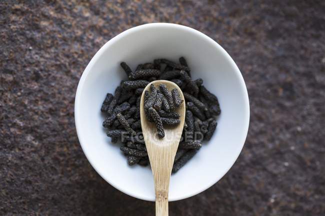 Dried long pepper with wooden spoon — Stock Photo