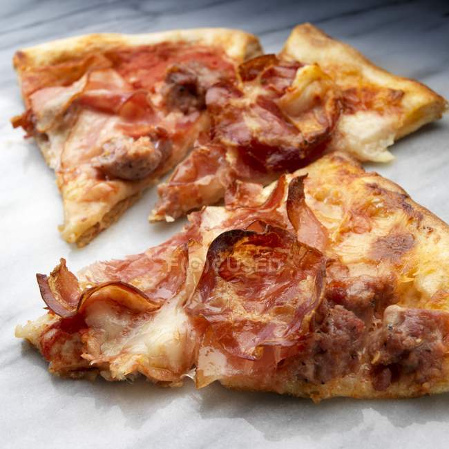 Кусочки пиццы с колбасой — стоковое фото