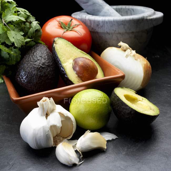 Складові для гуакамоле: авокадо, цибуля, помідор, часник і коріандр — стокове фото