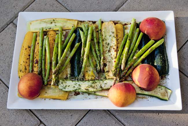 Verdure marinate e frutta per grigliate su piatto bianco — Foto stock