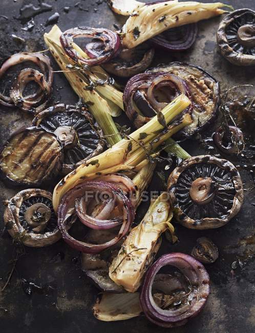 Roasted vegetables with balsamic vinegar on black surface — Stock Photo