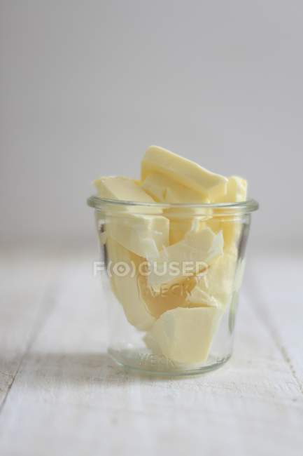 Chunks of butter in glass — Stock Photo