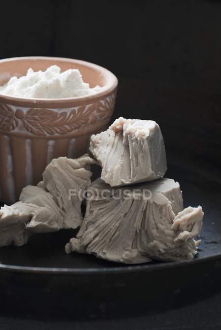Primo piano vista di lievito di cottura davanti a una pentola di argilla con crema — Foto stock