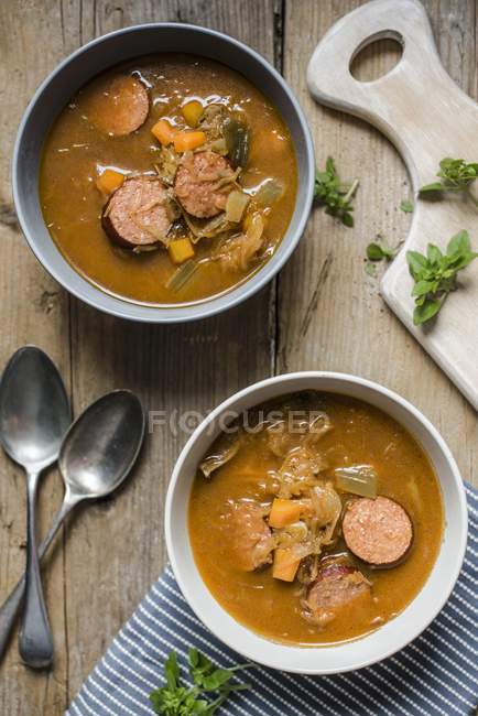 Flavoursome sauerkraut cabbage soup with smoked sausage — Stock Photo
