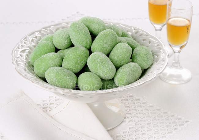 Closeup view of green marzipan eggs in stand with drinks — Stock Photo