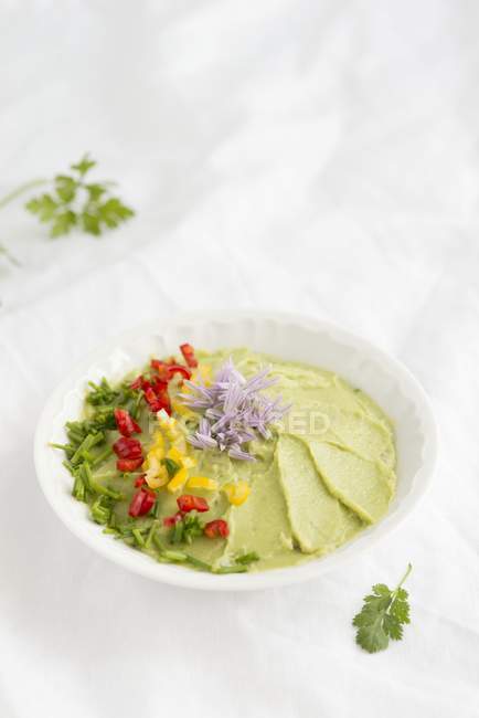Avocado dip with chilli and chives on white surface — Stock Photo