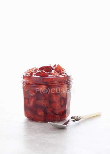 Closeup view of roasted strawberry sauce in glass jar — Stock Photo