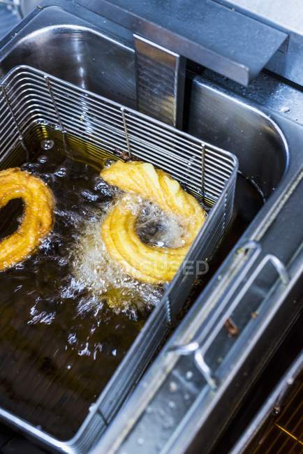 Elevated view of Churros in a deep fat fryer with oil — Stock Photo