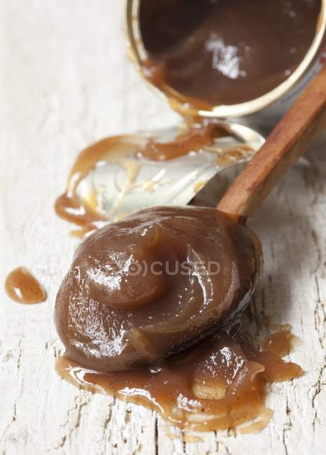 Closeup view of chestnut cream from a tin on a wooden spoon — Stock Photo