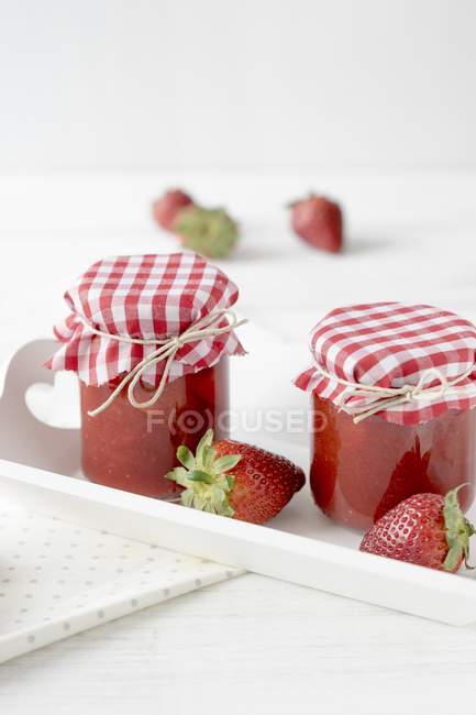Frascos de mermelada de fresa en bandeja - foto de stock
