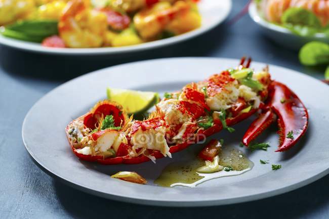 Closeup view of lobster half with oil, herbs and lime — Stock Photo