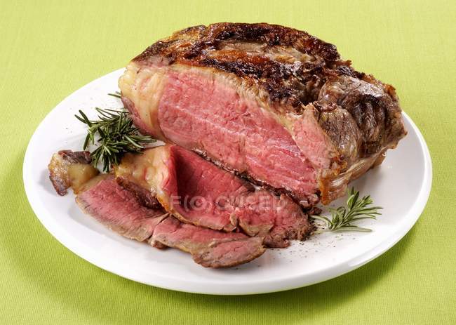 Carne assada fatiada com alecrim — Fotografia de Stock