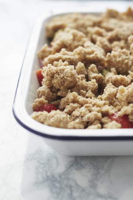 Closeup view of strawberry and rhubarb crumble in baking tray — Stock Photo