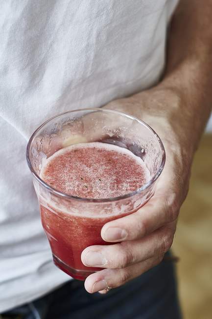 Man holding glass of smoothie — Stock Photo