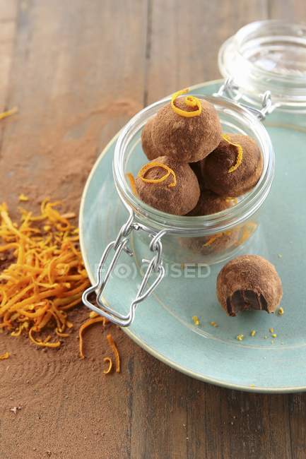 Vue rapprochée du chocolat végétalien et des truffes d'orange dans un bocal en verre — Photo de stock
